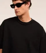 Remera oversized de algodón color crudo, con cuello redondo, manga corta, sin estampa y ribete acanalado.