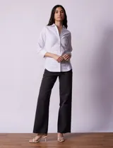 Camisa blanca de algodón marca Zac & Rachel, con cuello con solapa, abertura central con botones, delantera tableada y laterales elastizados.