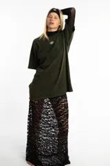 Pollera larga de encaje negro con diseño floral y volado en el ruedo.