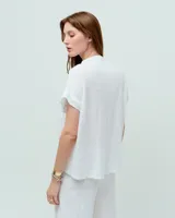 Remera celeste de lino y ramio, con corte boxy, manga japonesa, cuello mao, media cartera con broches metálicos y bolsillo plaqué con efecto de tapa.