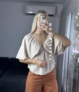 Blusa verde agua con escote en V, mangas cortas abullonadas y tiritas para atar.