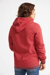 Buzo canguro de algodón color ladrillo con capucha ajustable, mangas largas, bolsillo canguro y logo estampado en el pecho.