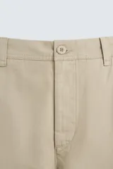 Pantalón chino color verde militar, de corte recto, con bolsillos laterales y traseros de vivo. Cierre frontal con cremallera y botón.