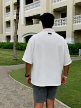 Camisa de hombre oversize de chenille color crema, con cuello clásico, manga corta y cierre frontal con botones de madera.