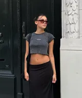 Remera corta gris con cuello redondo y mangas cortas con volados.