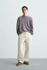Jersey color crudo de algodón con textura, corte relaxed fit, cuello redondo y manga larga. Acabados en rib con detalle de vuelta.