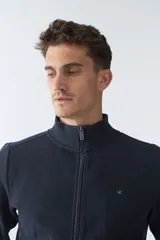 Campera marrón de algodón con cierre frontal, cuello alto, bolsillos laterales, puños y logo bordado en el pecho.