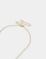 Collar corto con cadena dorada y dijes esmaltados: gato de la suerte japonés, cereza y corazón rojo.