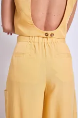 Pantalón ancho de tiro alto color vino, con pliegues frontales y bolsillos laterales.