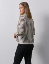 Blusa de gasa estampada a rayas verticales blancas y negras, marca Sioni. Espalda con abertura y botón. Manga larga con puño y botón.