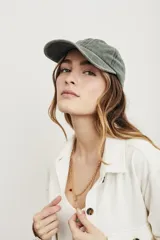 Gorra verde oliva de algodón lavado, estilo béisbol, con visera curva y correa ajustable en la parte trasera.