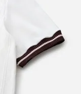 Remera de algodón color crudo con textura vertical, cuello redondo y mangas cortas con rib de color marrón.