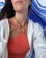 Collar con dije circular irregular de alpaca y plata 925, con hilo de algodón natural.