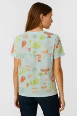 Remera amarilla con estampado de motivos playeros en blanco: soles, olas y conchas marinas.