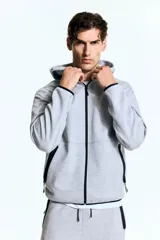 Campera deportiva gris con capucha, cierre frontal y bolsillos laterales con cierre. Confeccionada en tejido funcional DryMove™ que ayuda a absorber el sudor.