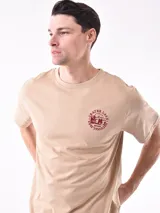 Remera blanca de corte recto con estampa fotográfica de edificios en la parte frontal.