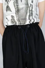 Bermuda holgada negra con cintura elastizada y hebillas de ajuste.