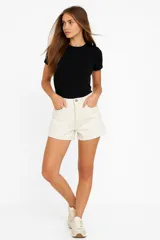 Short de jean color blanco, de calce alto y corte ajustado al cuerpo.