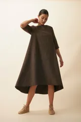 Vestido largo debajo de la rodilla, acampanado, color marrón, con cuello bote, bolsillos laterales y mangas 3/4 con detalle de tajo.