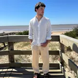 Camisa de manga larga color blanco, con textura de lino arrugado, cuello camisero y botones frontales.