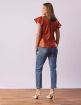 Blusa color naranja óxido de satén, marca Alex & Lili. Manga corta amplia con volados. Corte bajo el busto. Espalda con abertura ojal y botón.