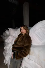 Campera corta marrón de pelo sintético con forro interior y puños de cuero sintético.