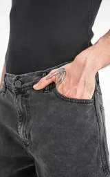 Bermuda de denim gris con efecto lavado, corte regular y ruedo desflecado.