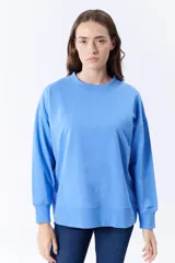 Buzo deportivo celeste de corte holgado, con cuello redondo y mangas largas.