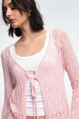 Cárdigan calado color blanco con mangas largas y lazo de ajuste frontal.