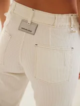 Jean de corte cigarette con detalles de pespuntes y cortes. Con bolsillos traseros.