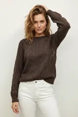 Sweater de punto acrílico color crema, con diseño de trenzas en el cuerpo y mangas, cuello redondo y calce holgado.