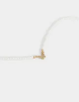 Cadena corta de perlas sintéticas con dije de mariposa dorada y cierre de mosquetón.