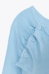 Top celeste de punto con cuello redondo amplio y manga larga. Detalle de frunces delanteros y botones en hombros forrados a tono.
