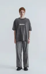 Remera gris con efecto nevado, cuello redondo y estampado frontal con la palabra 'Música' en blanco. Corte oversize y mangas cortas.