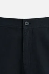 Bermuda azul marino de corte regular, confeccionada en tejido de algodón y lino. Cuenta con bolsillos frontales y traseros, cierre frontal con cremallera y botón.
