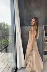 Vestido largo negro de un solo hombro, confeccionado en tela tableada con sutiles brillos.