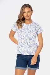 Remera blanca estampada con flores azules y beige, de manga corta y cuello redondo.