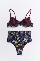 Conjunto de bikini negro y dorado, con corpiño triangular y bombacha clásica con cintura alta.