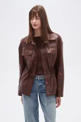 Chaqueta marrón de eco-cuero con textura de cocodrilo, cuello solapa, bolsillos con tapa en el pecho y frunces ajustables en la cintura mediante cordones.