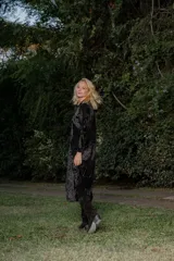 Bota alta de cuero color beige, estilo texana, con caña alta y taco bajo.