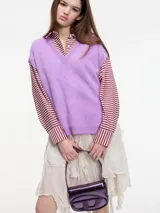 Chaleco sin mangas de cashmere color blanco, con escote en V y tajos laterales.