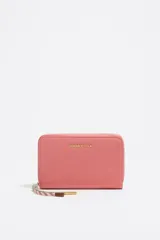 Billetera marrón de nylon con logo metálico de la marca Bimba y Lola. Tiene estructura blanda, acabados metálicos y cierre con cremallera.