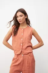 Chaleco color salmón con botones frontales y sin mangas.