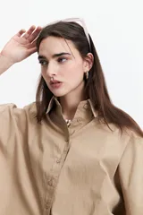 Camisa color beige de corte oversize y manga corta.