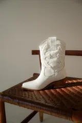 Bota texana negra de cuero con bordados y terminación en punta.