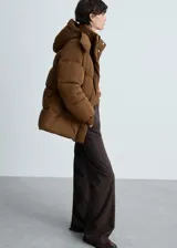 Campera puffer marrón con capucha, cierre frontal con cremallera y botones a presión, bolsillos laterales y puños elásticos.