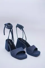 Sandalias de jean con plataforma y taco cuadrado, tira ancha sobre los dedos y pulsera con hebilla al tobillo.