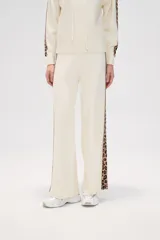 Pantalón de punto color crema, de corte ancho y tiro alto, con estampado animal print en los laterales.