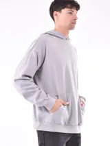 Hoodie gris claro de corte holgado, con capucha y bolsillo tipo canguro. Confeccionado en algodón.