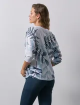 Buzo blanco con estampado de hojas en tonos azulados, de cuello redondo y mangas 3/4.